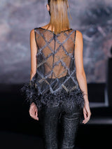 Blusa en organza bordada con cristales decorada con plumas en el bajo y pantalon pitillo en gran pique con lurex de Hannibal Laguna