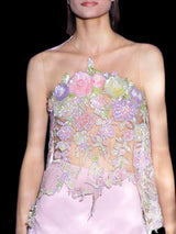 a woman in a pink dress holding a pink purse