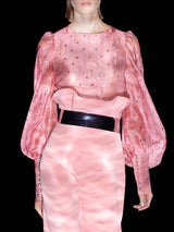 a woman in a pink dress holding a cell phone