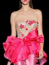 a woman in a pink dress holding a pink umbrella
