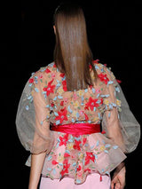 a woman in a pink dress holding a cake