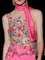 a woman in a pink dress holding a pink purse