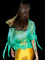 a woman in a green dress holding a toothbrush