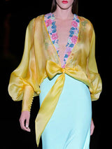 a woman wearing a yellow dress and a yellow dress