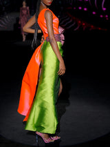 Vestido de fiesta midi en mikado color salmón y martelé color verde, cuerpo asimétrico y falda sirena y lazo XL granate rodeando la cintura de HANNIBAL LAGUNA.
