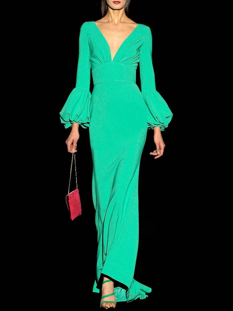 a woman in a green dress holding a cell phone 
