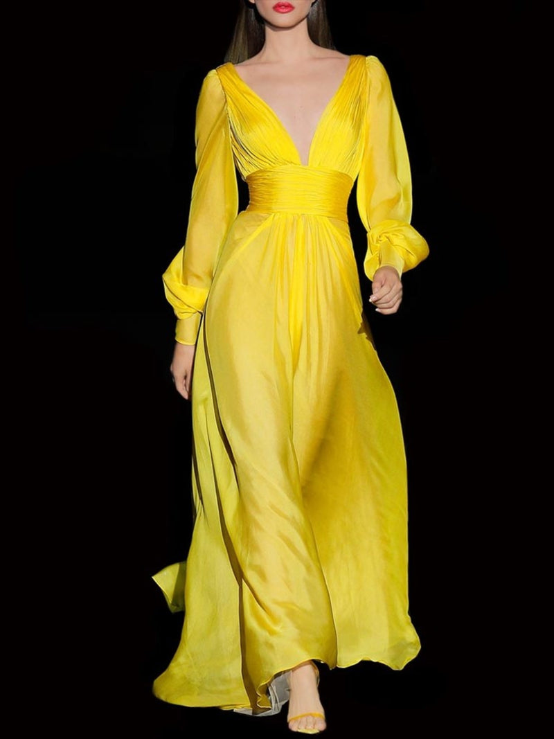 a woman in a yellow dress standing in a dark dress 