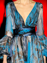 a woman in a blue dress holding a blue tie 